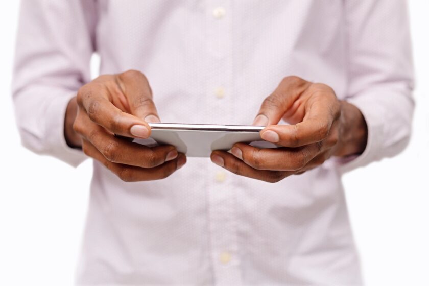 Mani con smartphone durante una partita multiplayer online